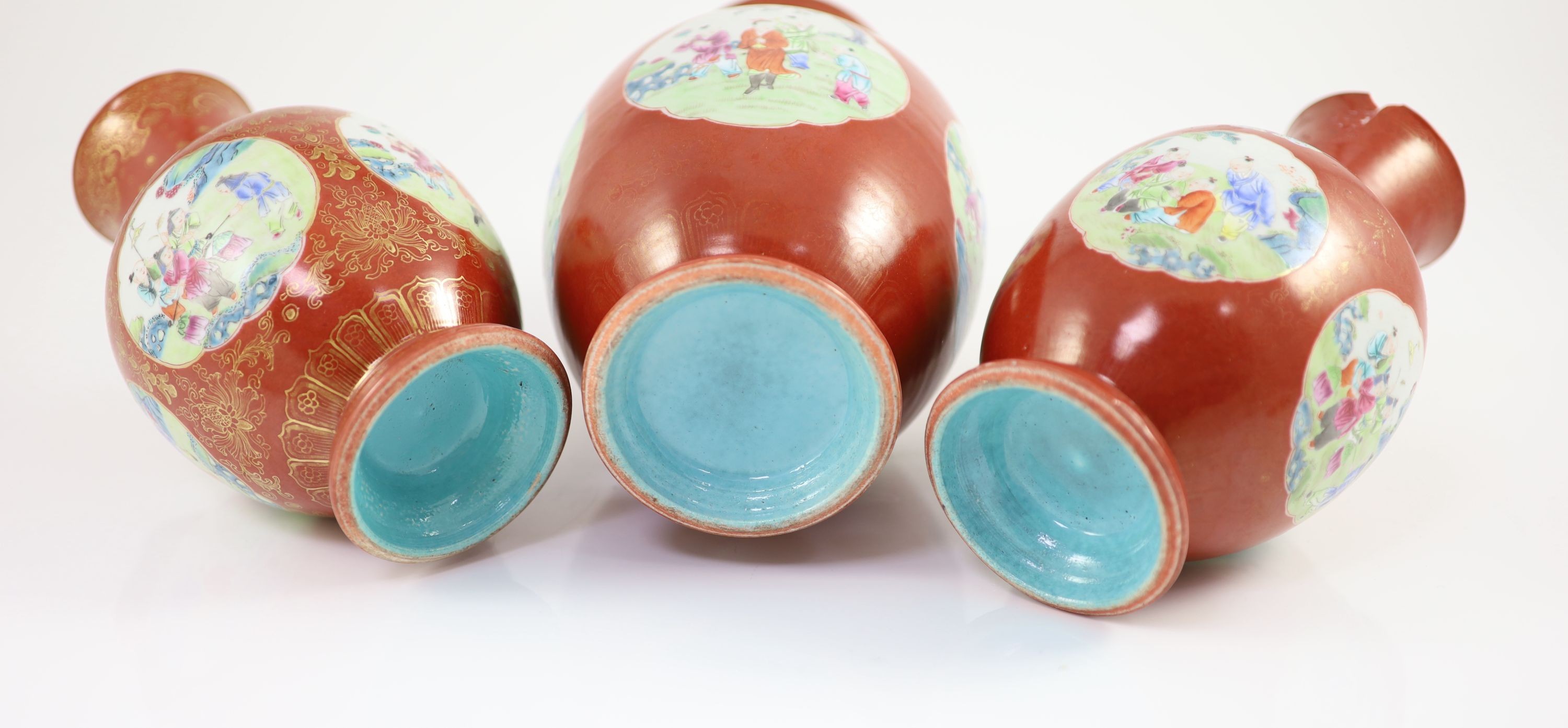 A set of three Chinese coral ground ‘boys’ vases, Jiaqing period (1796-1820), 19.5 and 23.5cm high